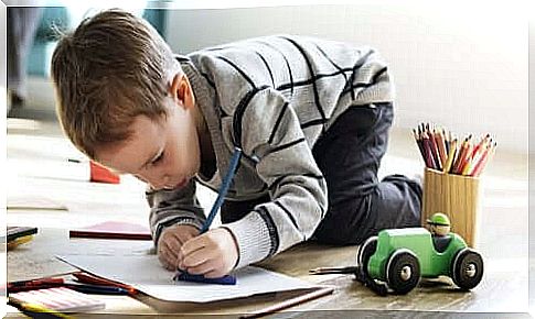 Child drawing on a paper with a pencil