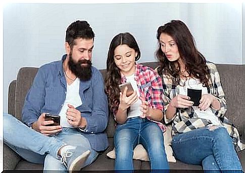 Father and mother surfing the internet together with their daughter using the phone.