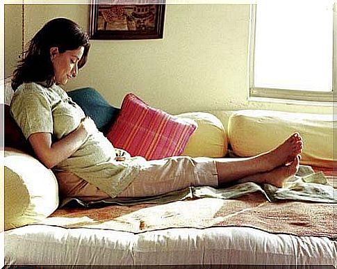 Pregnant woman rests on the sofa