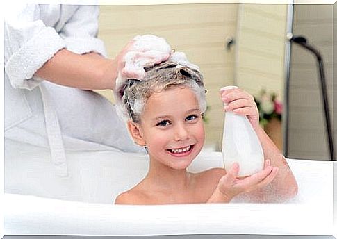 mother washes the hair to the baby in the tub