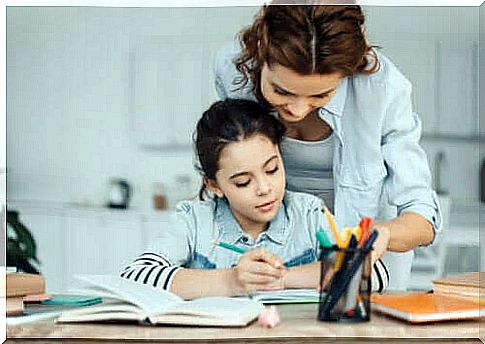 Little girl doing homework with mom's help.