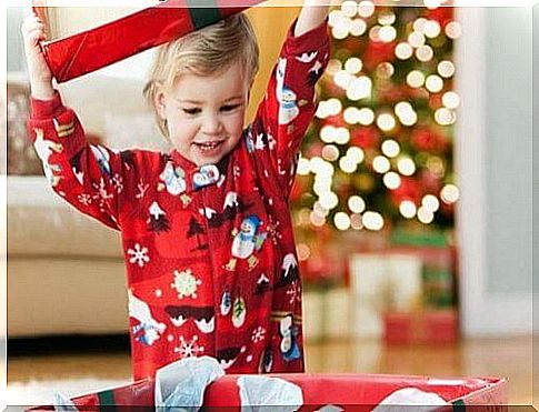 blond child unwraps christmas gift