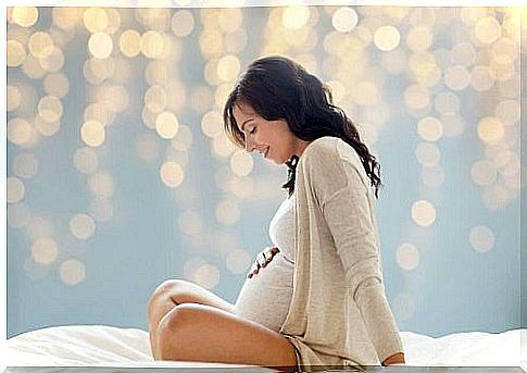 Pregnant woman sitting on the bed