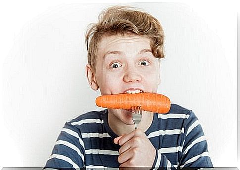 Teenager eating a carrot