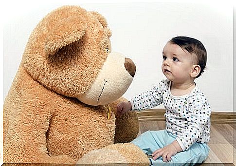 Child looks at soft toy