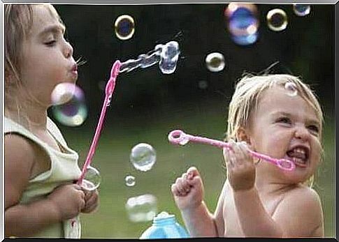 Little girls play with soap bubbles