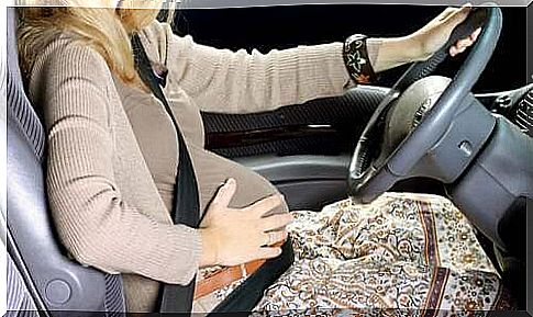 Driving during pregnancy: woman driving with a big belly.