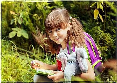 little girl with plush elephant and book transitional objects