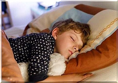 baby sleeping in bed with teddy bear