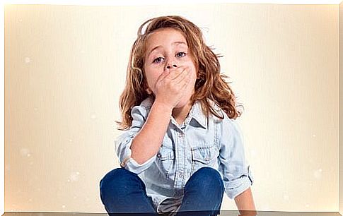 Little girl covering her mouth