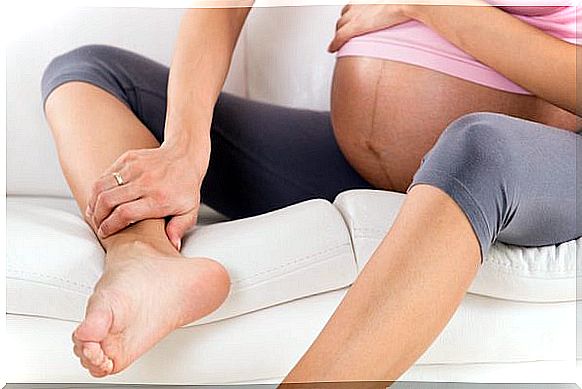 Varices in pregnancy, woman massages her ankles