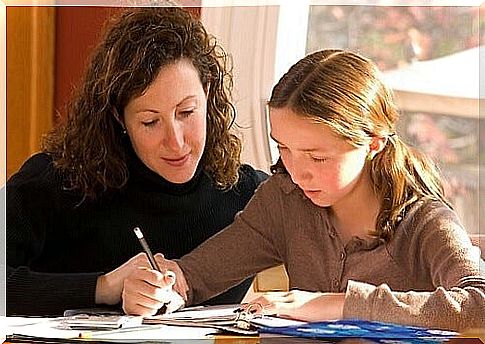 Mother supervises her daughter while she does her homework