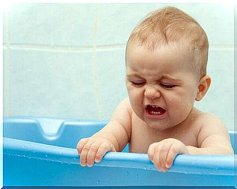 Newborn takes a bath in the tub