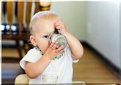 little girl drinks from a metal cup