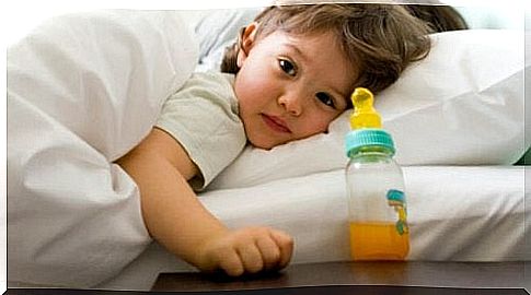 little girl in bed sideways with cups with orange juice