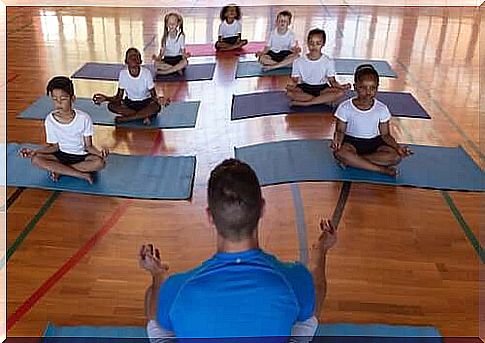 Children practicing yoga with their teacher.